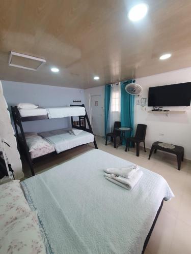 a bedroom with two bunk beds and a flat screen tv at Posada J&J Forbes - 1 in San Andrés