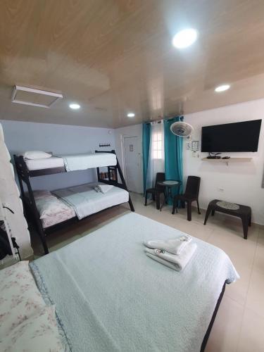 a bedroom with two beds and a flat screen tv at Posada J&J Forbes - 1 in San Andrés