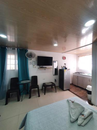 a room with a bed and a kitchen with a tv at Posada J&J Forbes - 1 in San Andrés