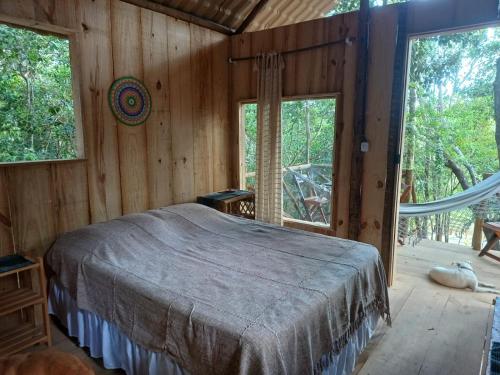 RECANTO DO SENTIR, conexão com a natureza e muita paz. في برايا دو فورتي: غرفة نوم مع سرير في غرفة مع نوافذ
