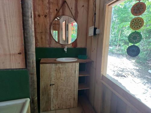 a bathroom with a sink and a mirror at RECANTO DO SENTIR, conexão com a natureza e muita paz. in Praia do Forte