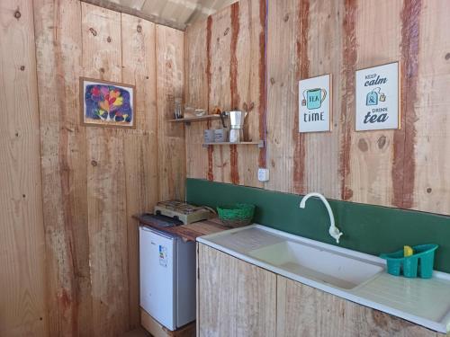 a kitchen with a sink and a washing machine at RECANTO DO SENTIR, conexão com a natureza e muita paz. in Praia do Forte