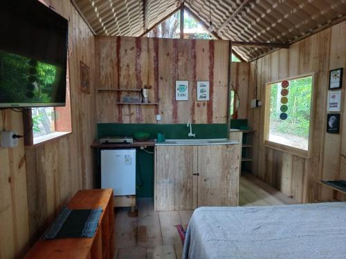 a room with a kitchen and a sink in a cabin at RECANTO DO SENTIR, conexão com a natureza e muita paz. in Praia do Forte