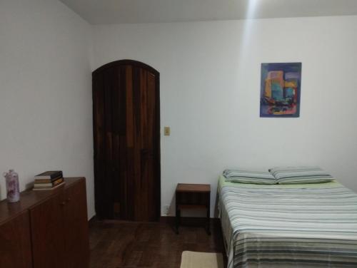 een slaapkamer met een bed en een houten dressoir bij Pousada rotas e ritmos in Sao Paulo