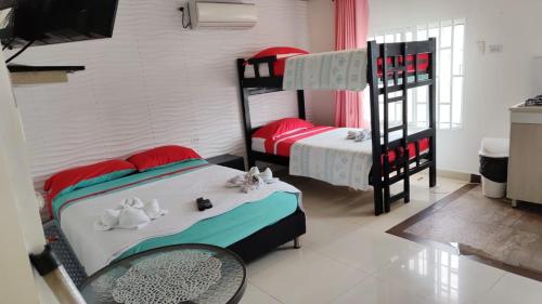 a bedroom with two bunk beds and a table at Posada J&J Forbes - 1 in San Andrés