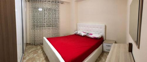 a small bedroom with a bed with a red blanket at Big apartment city center in Shkodër