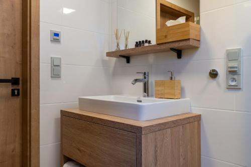 a bathroom with a white sink and a wooden cabinet at Chalet na Fialce in Albrechtice v Jizerských horách