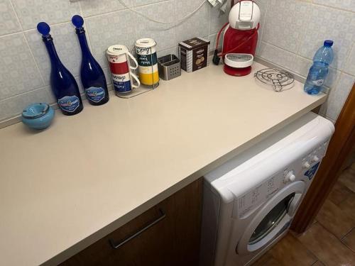 una encimera de cocina con lavadora y botellas. en Aguglia house citra: 011024-LT-0485, en Riomaggiore