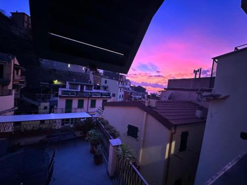 un balcón con vistas a la puesta de sol y a los edificios en Aguglia house citra: 011024-LT-0485, en Riomaggiore