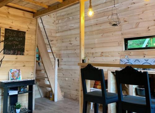 a room with wooden walls and two chairs and a staircase at Cabaña con Jacuzzi privado/BBQ y Chimenea ecológica in Guarne