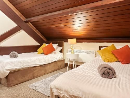 2 Betten in einem Zimmer mit Holzdecken in der Unterkunft 4-bed penthouse - Old Converted Church - FREE Parking in Pontypool