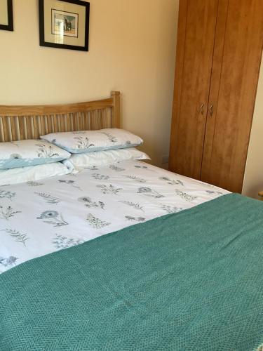 a bedroom with a bed with a green blanket at The Getaway, Miltown Malbay in Miltown Malbay