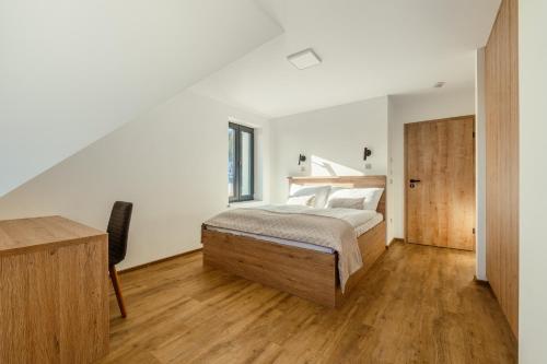 1 dormitorio con cama y escritorio en Chalet na Fialce, en Albrechtice v Jizerských horách