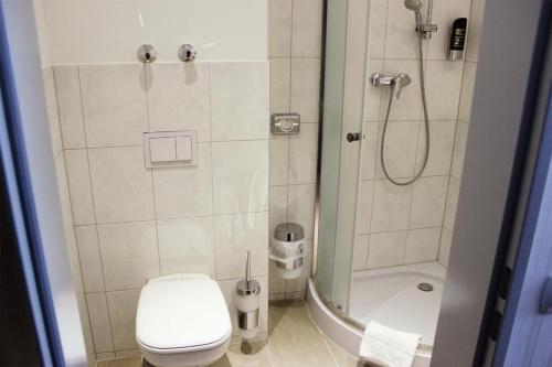 a bathroom with a shower with a toilet and a sink at Skyline Hotel Hannover in Hannover