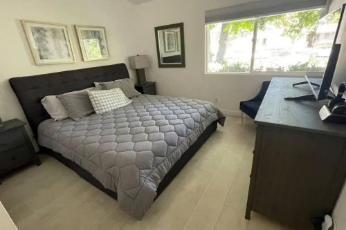 a bedroom with a bed and a desk with a laptop at Bright and cheerful 3 Bed-3 Bath house with pool in Los Angeles