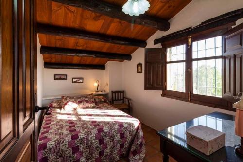 a bedroom with a bed in a room with windows at Casa Suryta einzigartiges Landhaus bei Granada in Dúrcal