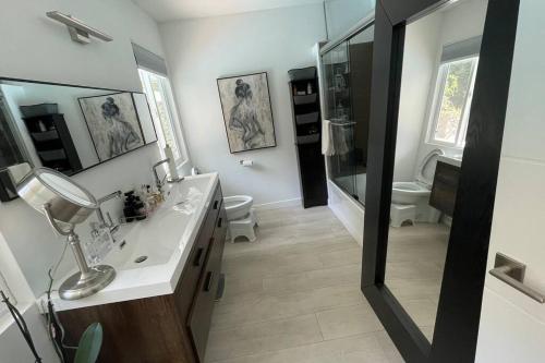 a bathroom with a sink and a toilet and a mirror at Bright and cheerful 3 Bed-3 Bath house with pool in Los Angeles