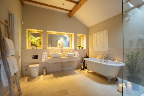 a bathroom with two sinks and two mirrors at Stable Lodge - Boutique Bed & Breakfast in Cheltenham