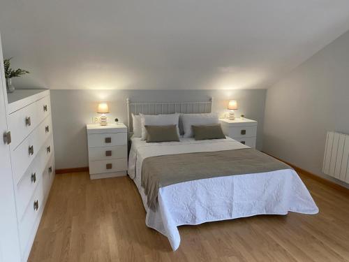 - une chambre avec un lit blanc et 2 tables de chevet dans l'établissement Casa da Morriña, à Cabana de Bergantiños