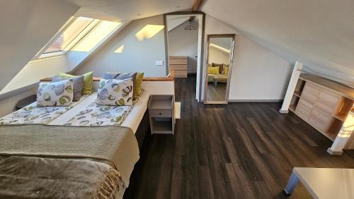 a attic bedroom with a bed and a mirror at Attic floor with views over fields and sea in Sigtuna