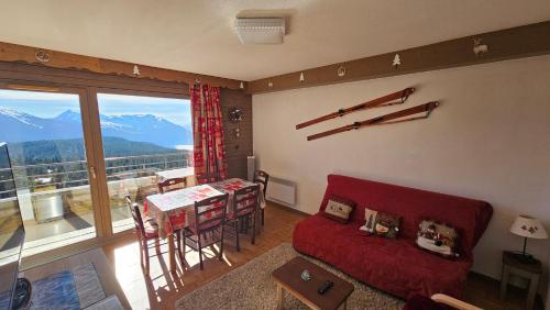 un salon avec un canapé rouge et une table dans l'établissement Appartement pieds des pistes, 6p, piscine ouverte pendant l'ouverture de la station, vue imprenable, Chamrousse, à Chamrousse