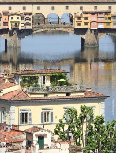 a bridge over a body of water with a building at Affittacamere Il Chiostrino Guest House in Florence