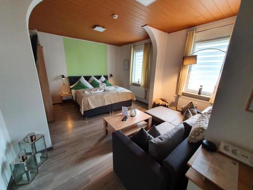 ein Wohnzimmer mit einem Bett und einem Sofa in der Unterkunft Wohlfuehl-Wohnung mit Sternekomfort und Balkon in Tanne in Tanne