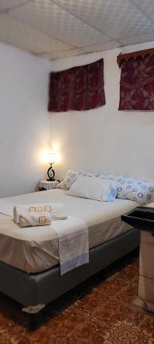 1 dormitorio con 1 cama grande y toallas. en Hostal Somotepek, en Somoto