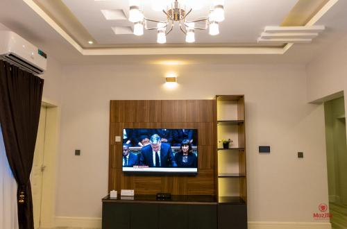 a living room with a television in a room at 99 MOZILLA APARTMENTS AND SUITES in Abuja