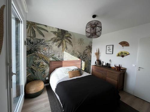 - une chambre avec un lit orné d'une fresque murale de palmiers dans l'établissement Appartement lumineux Colombes JO 2024, à Colombes