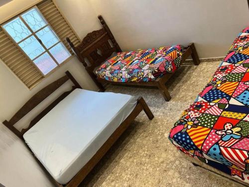ein Schlafzimmer mit einem Bett, einem Stuhl und einem Fenster in der Unterkunft Sítio MiranteMg em condomínio fechado in Itaúna