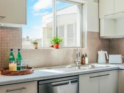 a kitchen counter with a sink and a window at XQ Collection Saltwater Bondi Beach in Sydney