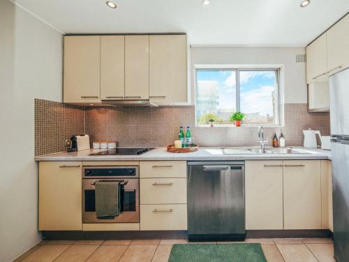 a kitchen with white cabinets and a sink at XQ Collection Saltwater Bondi Beach in Sydney