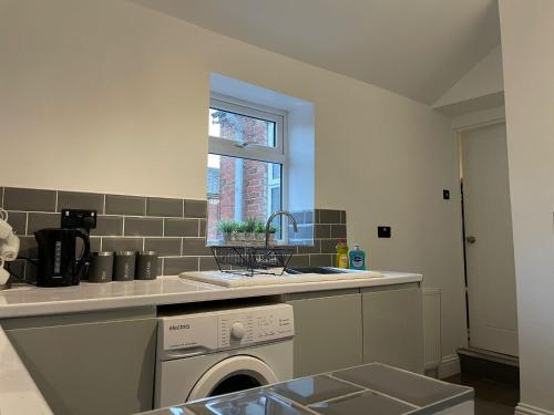 a kitchen with a washing machine and a window at Saltwell Rd - 4 Bdrm 5 beds Great for contractors in Gateshead