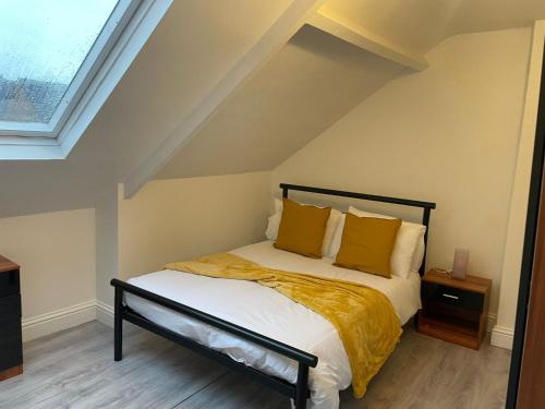 a bedroom with a bed with yellow blankets and pillows at Saltwell Rd - 4 Bdrm 5 beds Great for contractors in Gateshead