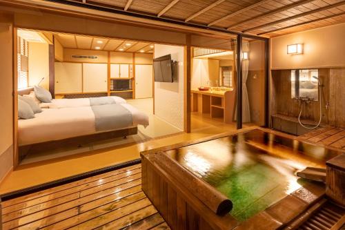 1 dormitorio con 1 cama y bañera en una habitación en Hotel Keisui, en Omachi