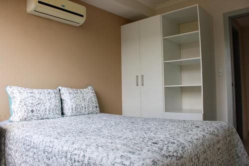 1 dormitorio con 1 cama y armario blanco en Great family apartment in Tegucigalpa, en Tegucigalpa