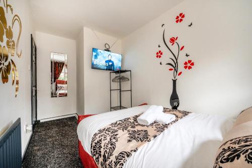 a bedroom with a bed and a tv on the wall at *RB26S* For your most relaxed & Cosy stay + Free Parking + Free Fast WiFi * in Adel