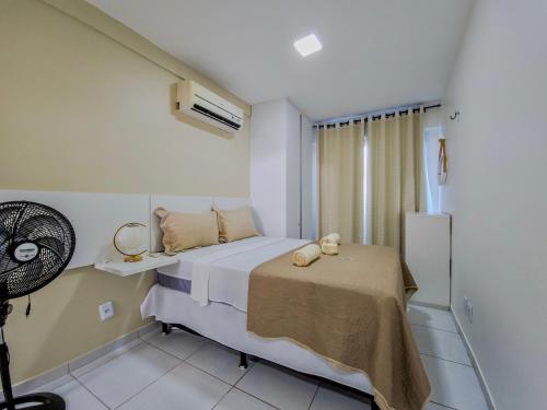 a bedroom with a bed and a fan at Aloha Vibes Ap Cumbuco - Green Club in Cumbuco