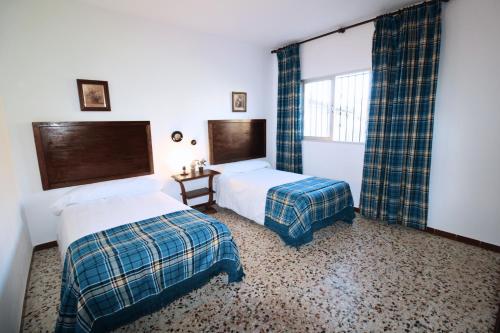 1 dormitorio con 2 camas y ventana en Casa Rural - La Fresquita, en Castaño de Robledo