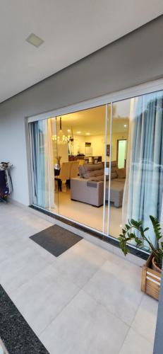 una sala de estar con una gran ventana corredera de cristal en Casa Sunstay Garden com piscina, en Bombinhas