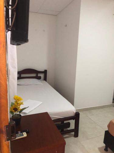 a small bedroom with a bed and a table at Mónaco habitaciones in Coveñas