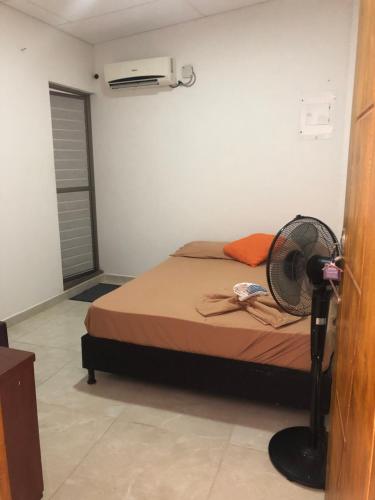 a bedroom with a bed with a fan on it at Mónaco habitaciones in Coveñas