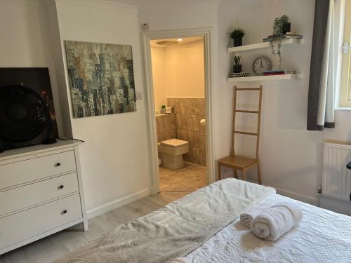 um quarto com uma cama e uma casa de banho com um chuveiro em Luxe Haven King Bed En-suite & Double with Parking em Londres