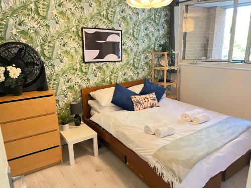 Un pequeño dormitorio con una cama con toallas. en Luxe Haven King Bed En-suite & Double with Parking, en Londres