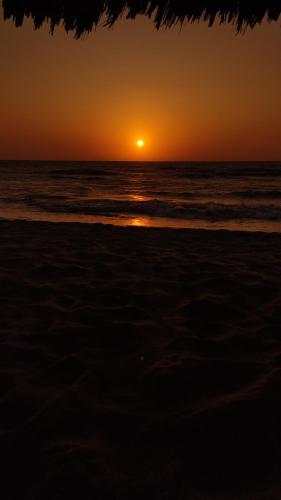 a sunset on the beach with the ocean at Rincón del mar Veleros Hotel in San Onofre
