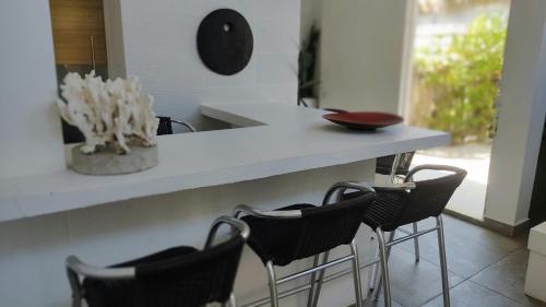a kitchen with a counter with chairs and a vase at Rincón del mar Veleros Hotel in San Onofre