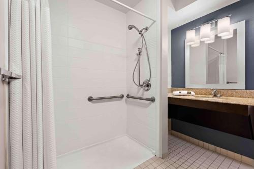 uma casa de banho com um chuveiro e um lavatório. em Extended Stay America Suites - St Louis - Fenton em Fenton