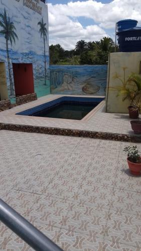 uma piscina no meio de um edifício com palmeiras em Pousada vista pro vale do catimbau em Catimbau