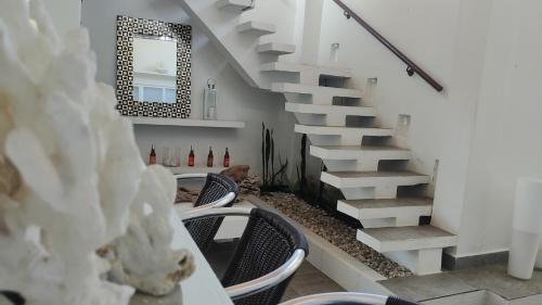 a man sitting in a chair under a staircase at Rincón del mar Veleros Hotel in San Onofre